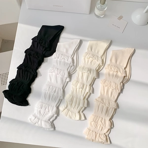 Détail de volants en dentelle multicouches sur des chaussettes en coton en quatre couleurs