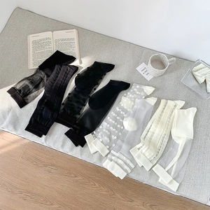Detailed flat lay of black and white polka dot sheer mesh knee-high socks for women