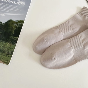 Close-up of beige ribbed cotton crew socks with minimalist lifestyle magazine aesthetic
