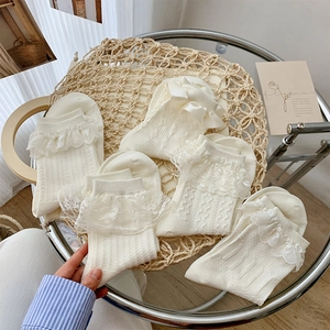 Close-up of white Lolita lace socks with vertical stripes and satin bow details