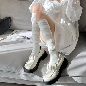 Détail de mocassins à plateforme blanc cassé avec chaussettes à volants style écolière