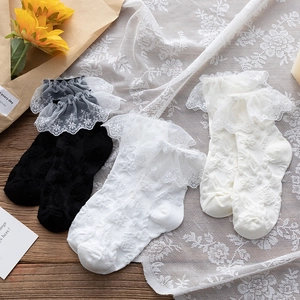 Detailed view of white lace trim socks featuring delicate floral embroidery and layered ruffles