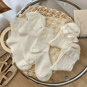 Detailed macro view of cream white lace ruffles and vertical knit texture on Lolita socks