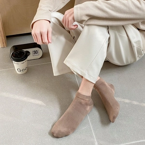 Men's ribbed low-cut cotton sports socks in beige, styled with casual trousers