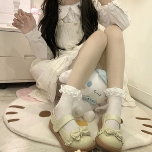 Lolita style light green Mary Jane shoes with frill trim and bow, styled with lace socks