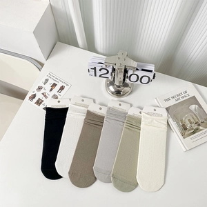 Assorted six-color set of cotton crew socks with ruffled cuffs on a minimal white desk