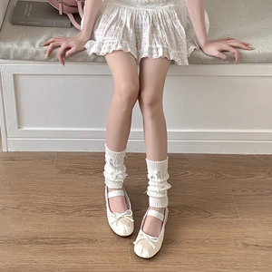 Détail de jambières blanches tricotées avec nœud décoratif et style balletcore
