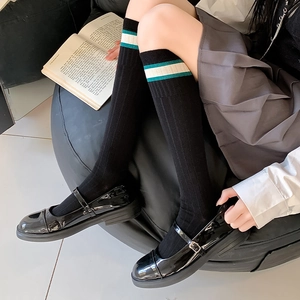 Detail of white striped knee high socks paired with black Mary Jane shoes for school style