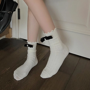 White ballet core calf socks with frilly edges and black rhinestone bows side view