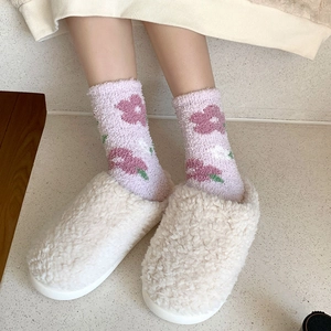 Dettaglio di calzini floreali in pile corallo e pantofole di peluche per l'inverno