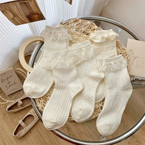 Detailed macro shot of cream lace ruffle socks with vertical stripes and ribbon bows