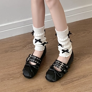 Détail des jambières blanches en maille avec nœuds et chaussures Mary Jane noires