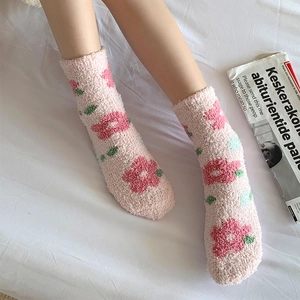 Dettaglio calzini in pile corallo rosa con motivo floreale per calore invernale e casa