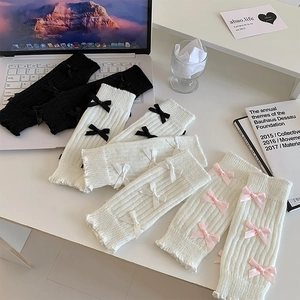 Détail de jambières en tricot avec des nœuds en ruban en styles noir et blanc