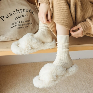 Plüschige Hausschuhe mit Überkreuz-Riemen in Off-White und warme Strick-Socken