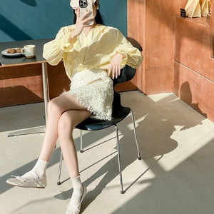 Chic cream mesh socks paired with beige ballet flats and fringe skirt in natural light
