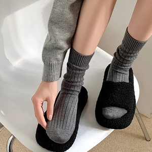 Dicke graue gerippte Socken kombiniert mit schwarzen flauschigen Fleece-Plateaubaumeln