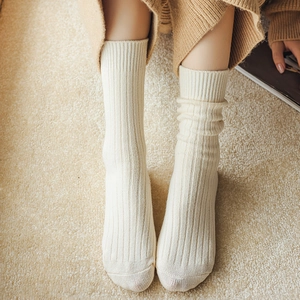 Detail von cremeweißen gerippten Mid-Calf-Wollsocken für Damen mit vertikalen Strickstreifen