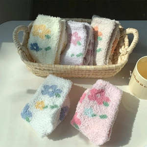 Dettaglio di calze spesse in pile corallo con motivi floreali in colori pastello