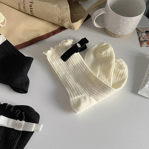 Detailed view of ballet-style socks with silk bows and rhinestones on soft ribbed cotton
