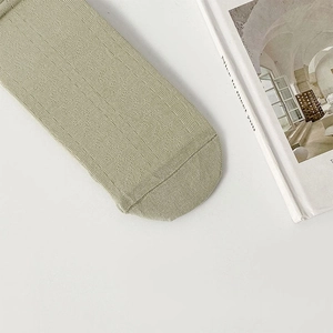 Close-up of olive green knitted socks with fine vertical rib texture and neat toe seams