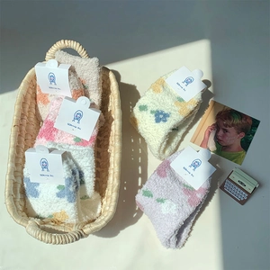 Dettaglio di cinque paia di calze spesse in pile corallo con motivi floreali pastello