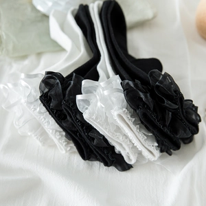 Close-up of Lolita style white and black crew socks with multilayered lace ruffled edges