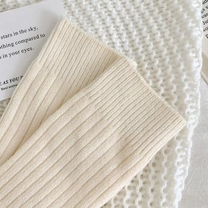 Detailaufnahme der cremeweißen Rippstrick-Textur und des dicken, warmen Stoffes