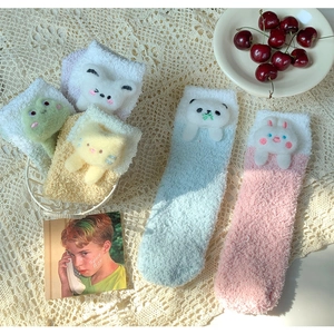 Close-up of thick coral fleece socks with 3D cartoon animal dolls in pastel colors