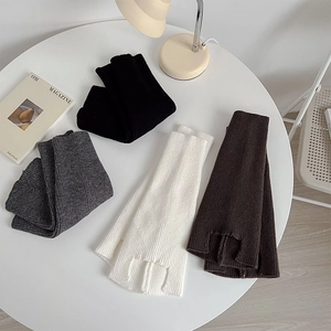 Detailed knit texture of four-color leg warmers with side slit on a minimalist desk