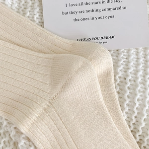 Nahaufnahme cremefarbener Rippstrick-Socken mit dicker warmer Textur und elegantem Muster