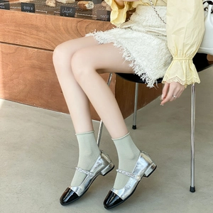 Silver metallic and black Mary Jane shoes with pearl rhinestone straps on model