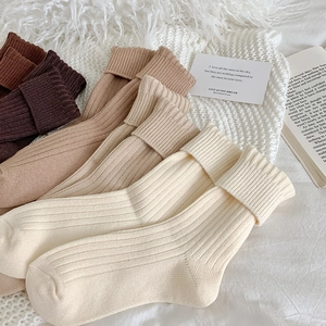 Detailaufnahme der Strickstruktur dicker Thermosocken mit vertikalen Rippen in Erdtönen