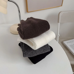 Close-up of thick ribbed knit leg warmers in black, white, brown and gray colors