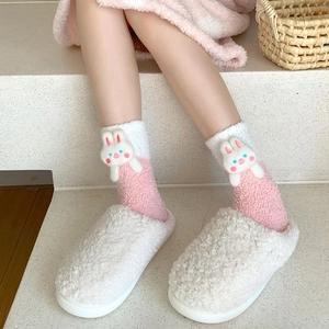 Detail of plush coral fleece socks with 3D bunny doll and cozy fleece slippers for winter