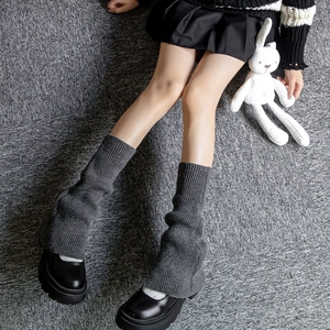 Detailed texture of dark grey ribbed knit leg warmers with soft fabric folds