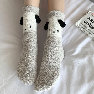 Détail de chaussettes en molleton corail avec oreilles 3D et visages de chien brodés