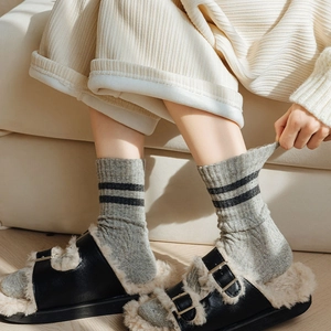 Thick wool socks in light grey with black stripes and cable knit texture for winter