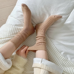 Detail von hellbeige gerippten Stricksocken mit elastischem Bund und warmer Wintertextur