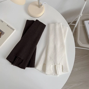 Detail of knitted leg warmers showing vertical ribbed texture in dark brown and off-white