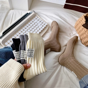 Cozy thick rib knit mid-calf socks in neutral tones with stylish woven heel labels