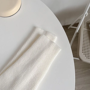 Macro shot of white ribbed knit fabric texture with vertical striped knitting details