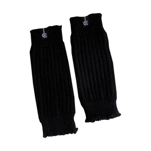Minimalist black knitted leg warmers with vertical ribs and a logo patch detail