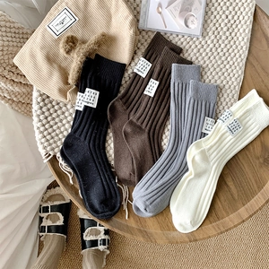 Close-up of ribbed knit crew socks with white numeric labels in various neutral colors