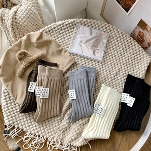 Detailed flat lay of five-color thick ribbed cotton crew socks with heel brand labels