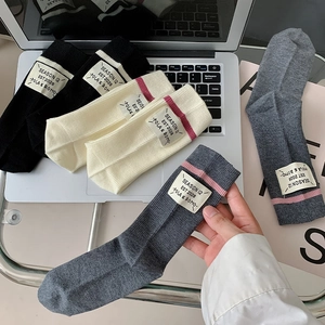 Detail of wool blend socks with vintage fabric label and striped ribbed texture