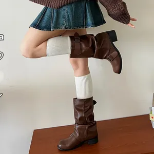 Detail of brown slouchy leather boots with side buckle and vintage pleated texture