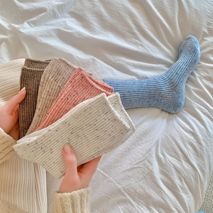Detailed close-up of thick winter wool blend socks showing diverse colors and ribbed texture
