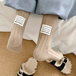Beige ribbed knit mid-tube socks featuring a white brand label and warm autumn style