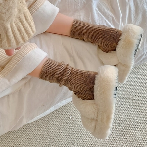 Detailed texture of thick brown ribbed knit wool socks paired with white fuzzy slippers